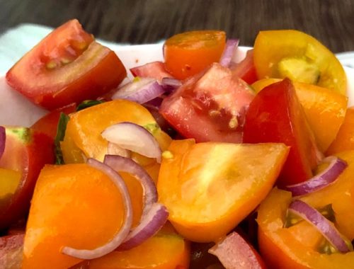 Image contains a photo of a bowl of chopped tomatoes with red onion, basil, chili flakes, oil, and vinegar.