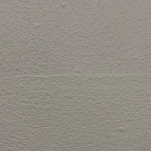Image contains a photo of a painted white wall with small bumps and a thin line going across the middle.